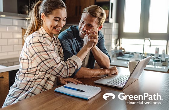 Couple giving each other a high five while budgeting