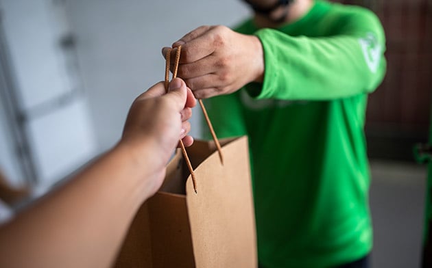 Man handing bag to other person