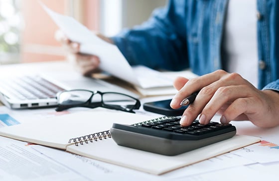 Picture of man sitting down doing his taxes. 