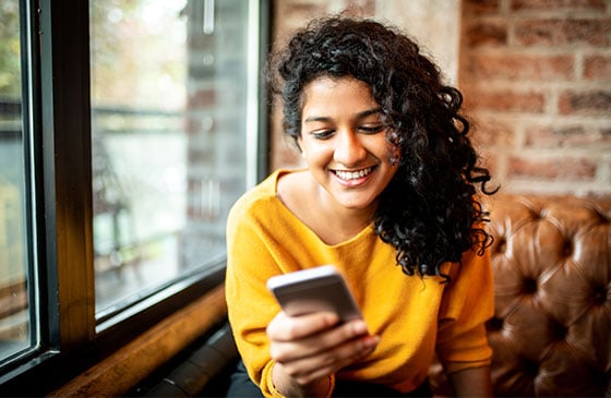 Person using phone to validate digital banking access for credit union checking account