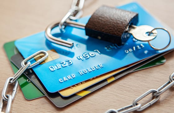 Chains being unlocked over credit cards to show breaking free from debt. 