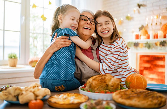 Family gathered around a holiday dinner table, celebrating together while highlighting smart holiday budgeting tips for gifts, travel, and seasonal expenses.